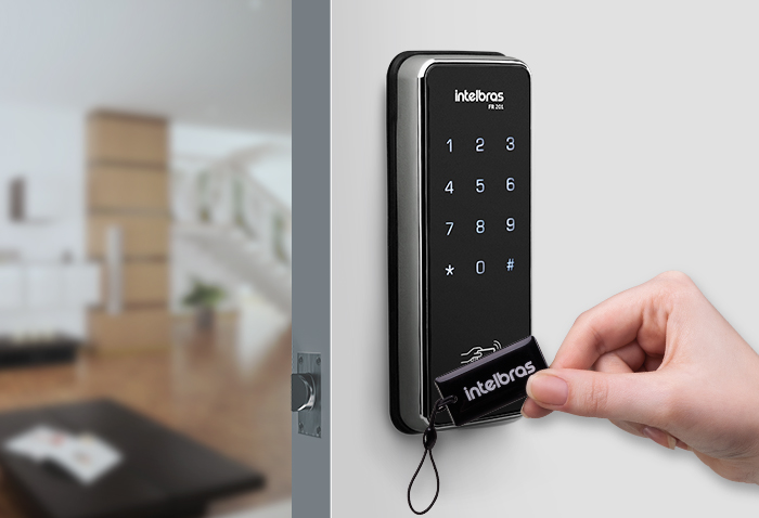 Mão a aproximar um cartão de acesso (tag) de uma fechadura digital